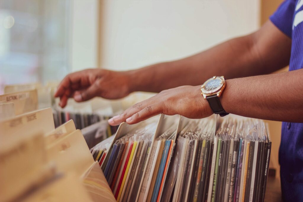 pexels-photo-2333420-2333420 Close-up of hands browsing vinyl records in a store, showcasing a classic vintage collection.